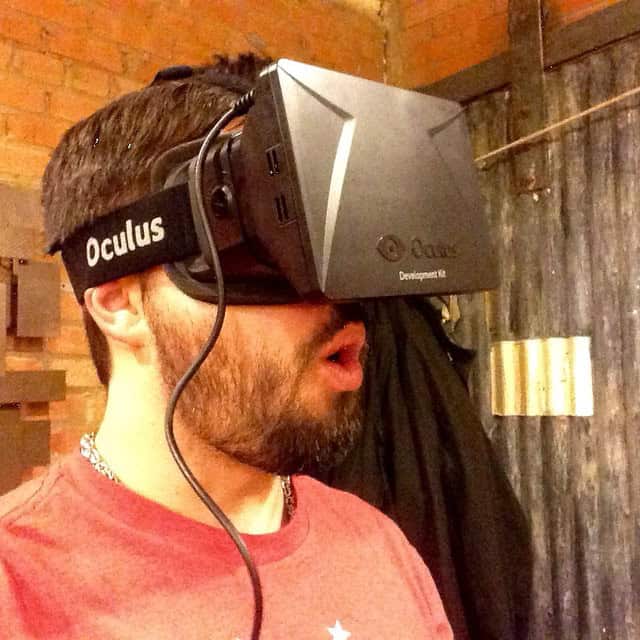 Man wearing Oculus VR headset experiencing virtual reality gaming.